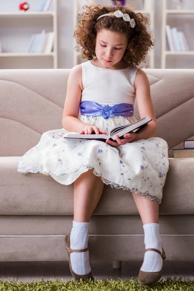 Pequeña chica bonita leyendo libros en casa — Foto de Stock