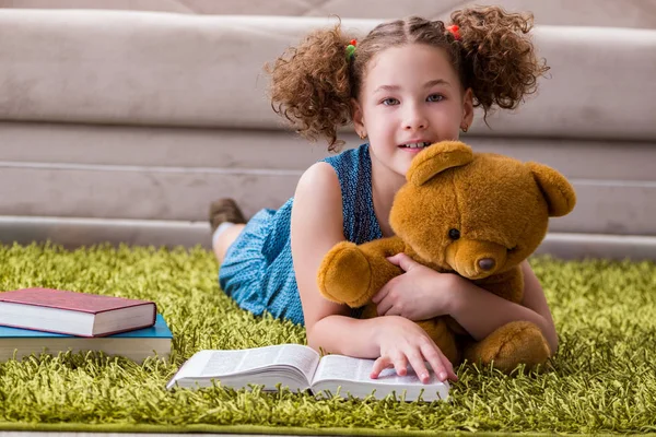 Pequeña chica bonita leyendo libros en casa — Foto de Stock