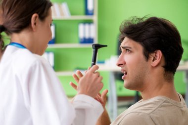 Tıbbi muayene sırasında kadın doktor hastaların kulaklarını kontrol ediyor. 