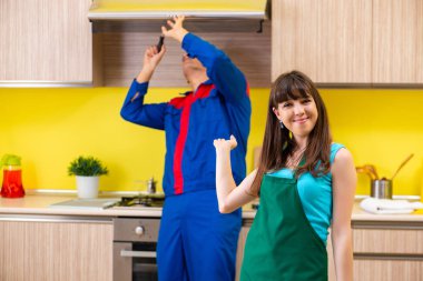 Woman with contractor at kitchen discussing repair clipart