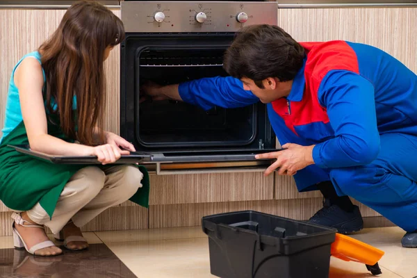 Frau diskutiert mit Bauunternehmer in Küche über Reparatur — Stockfoto