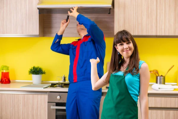 Mulher com empreiteiro na cozinha discutindo reparação — Fotografia de Stock