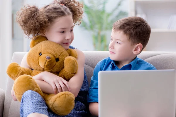 Двое детей сидят дома за ноутбуком — стоковое фото