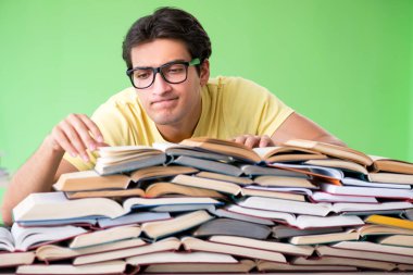 Sınavdan önce okumak için çok fazla kitabı olan öğrenci