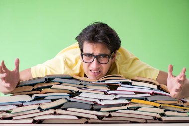Sınavdan önce okumak için çok fazla kitabı olan öğrenci