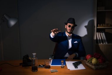 Dedektif karanlık odada klasik bir konseptle oturuyor.