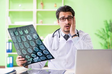 Doktor radyoloji uzmanı hastanede röntgen taramasına bakıyor.