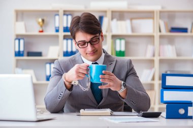 Kahvesine kelepçelenmiş bir iş adamı.