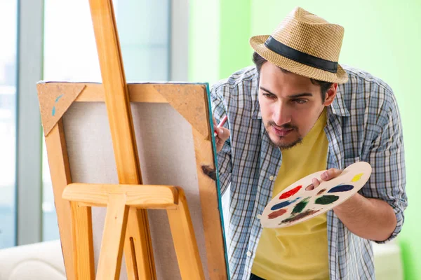 Mladý umělec pracuje na nové malbě ve svém ateliéru — Stock fotografie