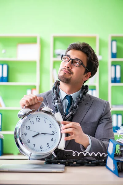 Werknemer geketend aan zijn bureau als gevolg van werkbelasting — Stockfoto