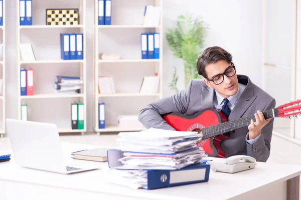 Jeune homme d'affaires beau jouant de la guitare dans le bureau — Photo