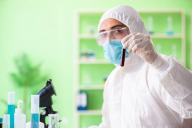 Laboratuvarda yeni bir deney üzerinde çalışan kimyager.