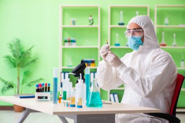 Laboratuvarda yeni bir deney üzerinde çalışan kimyager.