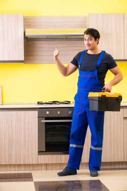 Genç müteahhit mutfak mobilyalarını monte ediyor.