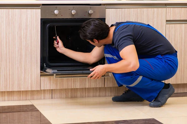 Jovem empreiteiro de serviços montagem de mobiliário de cozinha — Fotografia de Stock