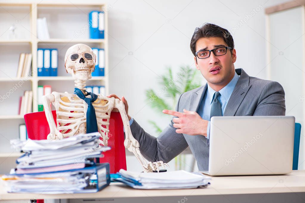 Businessman working with skeleton in office