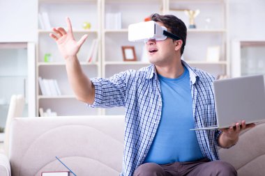 Evde sanal gerçeklik gözlükleriyle serbest çalışan bir öğrenci.