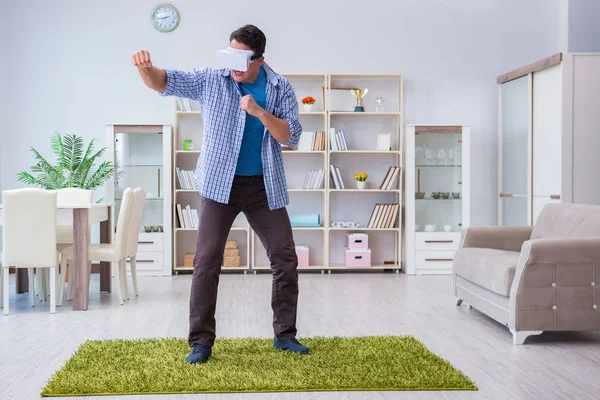 Homem com óculos de realidade virtual jogando em casa — Fotografia de Stock