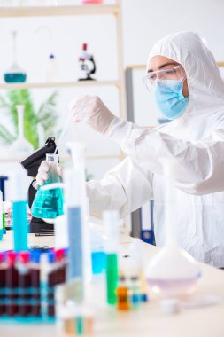 Laboratuvarda kimyasallar üzerinde çalışan genç bir kimyager.