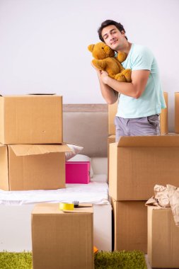 Young man moving to new apartment clipart
