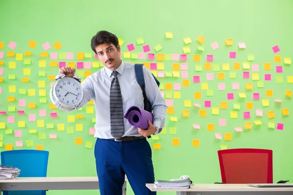 Sportive man in the office with many conflicting priorities in time management concept