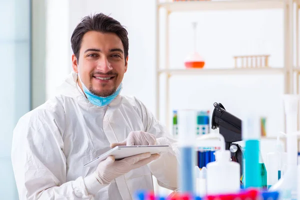 Joven estudiante de química trabajando en laboratorio sobre productos químicos —  Fotos de Stock