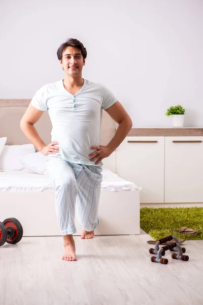 Jongeman doet ochtendroutine in de slaapkamer — Stockfoto