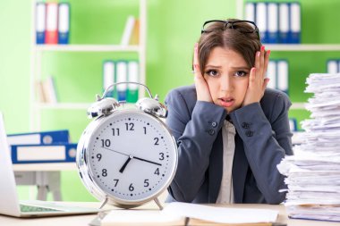 Genç bayan çalışan, süregelen evrak işleriyle çok meşgul.