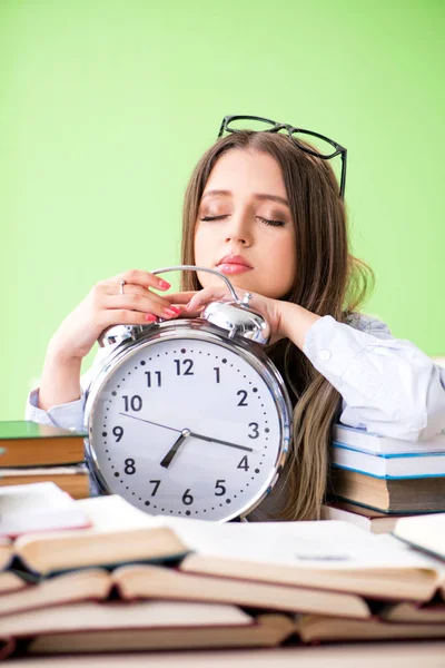 Jonge vrouwelijke student bereidt zich voor op examens met veel boeken in de tijd — Stockfoto