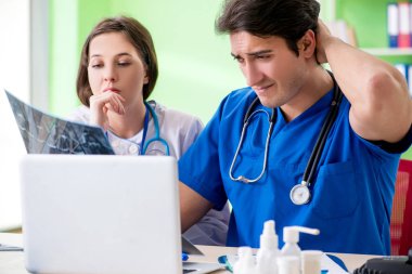 Kadın ve erkek jinekologlar Clini 'de tıbbi durumu tartışıyorlar.