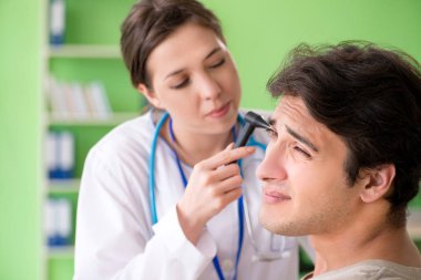 Tıbbi muayene sırasında kadın doktor hastaların kulaklarını kontrol ediyor. 