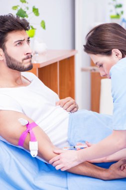 Woman doctor examining male patient in hospital clipart