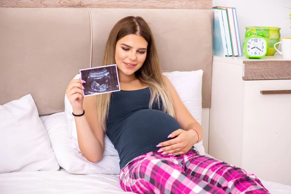 Joyeux jeune femme enceinte dans le lit — Photo