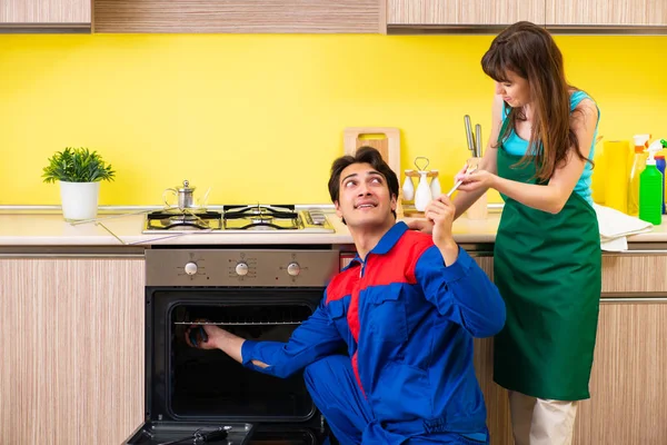 Mulher com empreiteiro na cozinha discutindo reparação — Fotografia de Stock