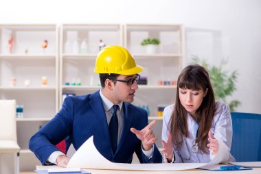 Doktor mimarla yeni hastane planını tartışıyor.