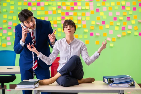 Férfi és nő az irodában sok egymásnak ellentmondó prioritások — Stock Fotó