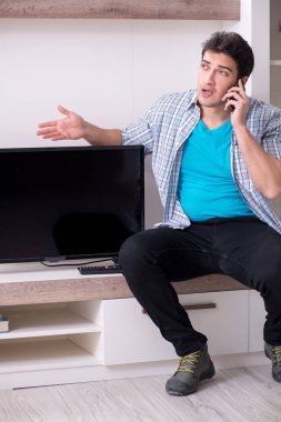 Bozuk televizyonu tamir etmeye çalışan adam