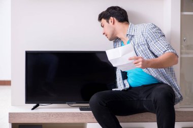 Bozuk televizyonu tamir etmeye çalışan adam