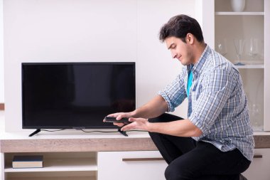Bozuk televizyonu tamir etmeye çalışan adam