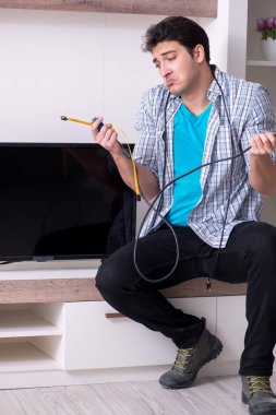 Bozuk televizyonu tamir etmeye çalışan adam