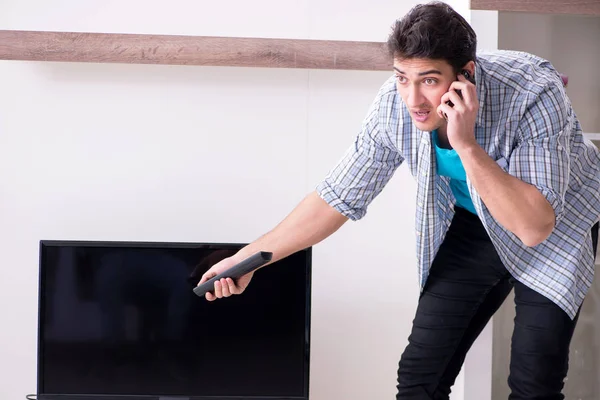 Man trying to fix broken tv — Stock Photo, Image