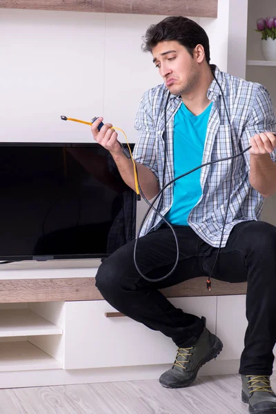 Hombre tratando de arreglar la televisión rota —  Fotos de Stock