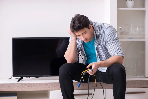 Homem tentando corrigir tv quebrado — Fotografia de Stock