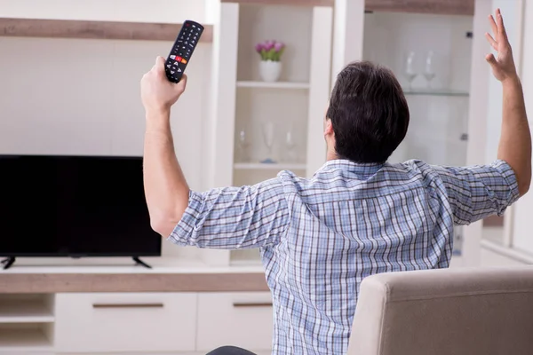 Молодий чоловік дивиться телевізор вдома — стокове фото