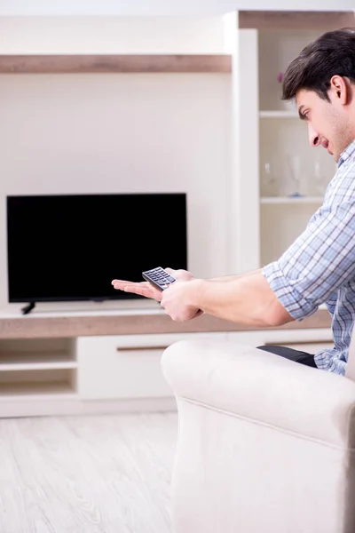 家でテレビを見ている若い男 ロイヤリティフリーのストック写真