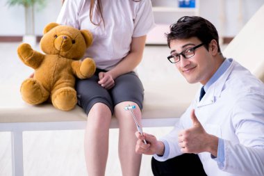Doktor genç kızları çekiçle kontrol ediyor.