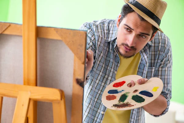 Joven artista masculino trabajando en una nueva pintura en su estudio —  Fotos de Stock