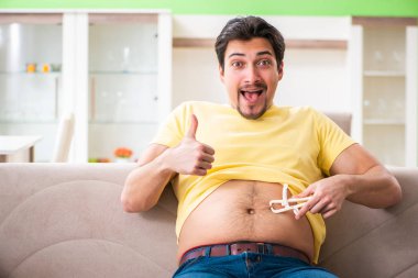 Vücut yağlarını kalibre ile ölçen genç bir adam. 