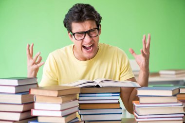 Sınavdan önce okumak için çok fazla kitabı olan öğrenci