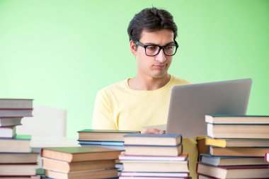 Sınavdan önce okumak için çok fazla kitabı olan öğrenci